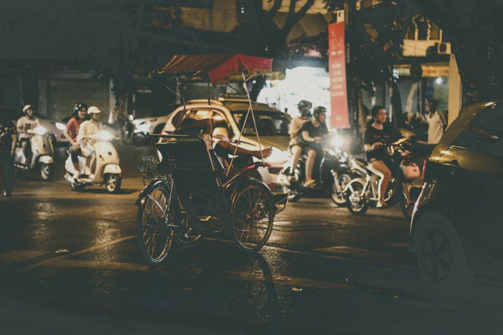 Xe máy và xích lô trên phố Hàng Bông, Hà Nội về đêm