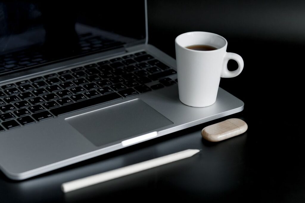 Laptop và tách cà phê trên bàn làm việc, minh họa bài viết về áp lực tìm việc kéo dài